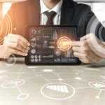 man holding tablet with charts and graphs surrounding him